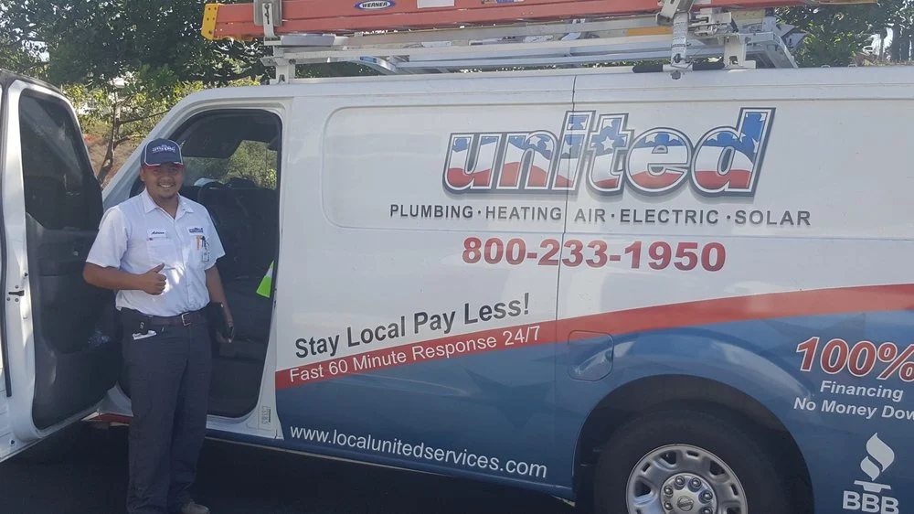 United Plumbing, Heating, Air & Electric technician standing beside a branded service van